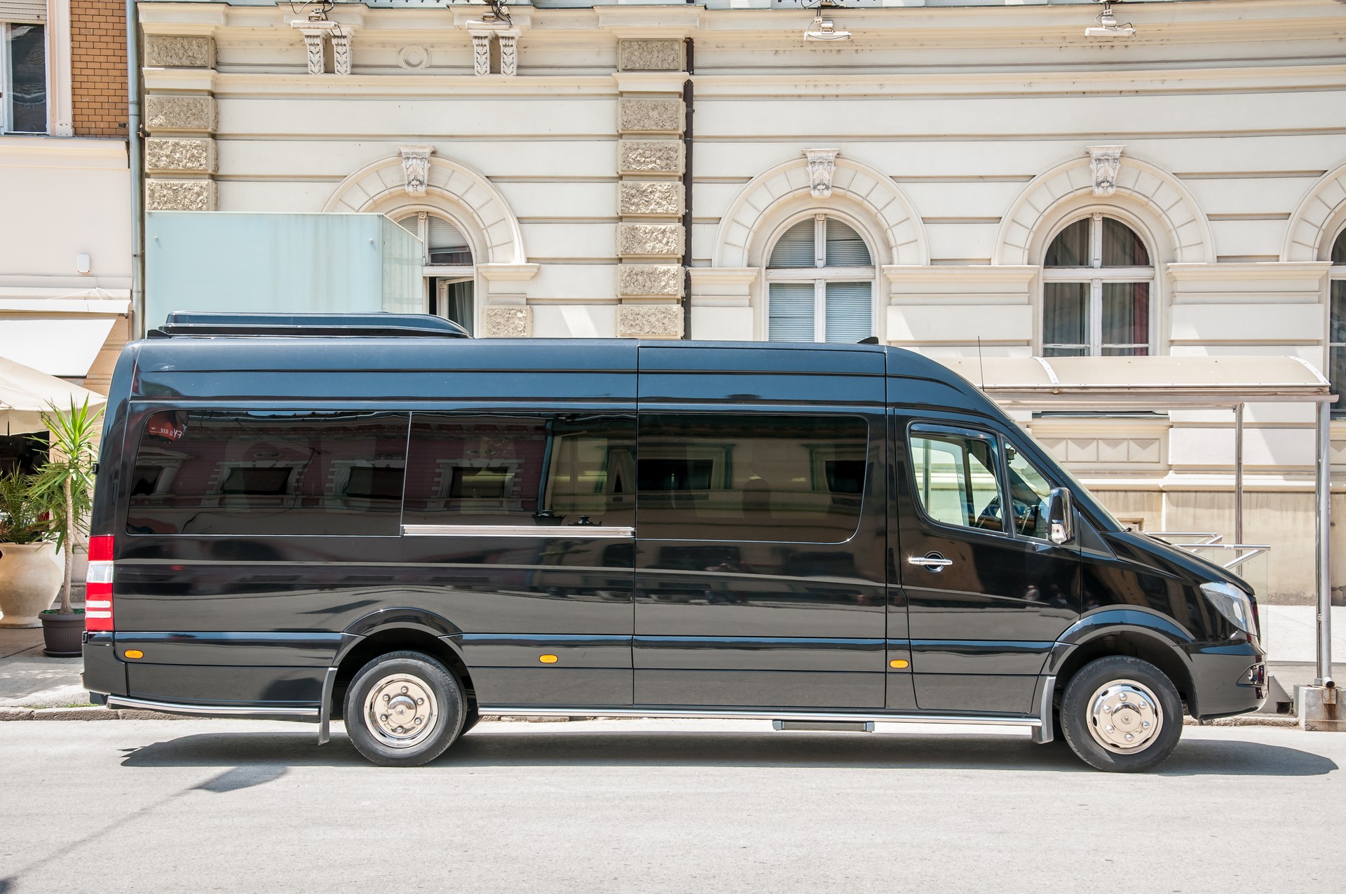 Mercedes Benz sprinter black luxury shuttle bus van parked on the street